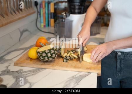 Woman slicing fruit in kitchen, midsection Stock Photo