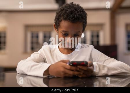 Boy using smart phone at home Stock Photo