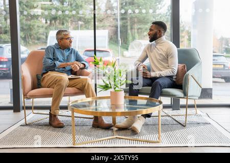 Businessman having one on one meeting with younger employee Stock Photo