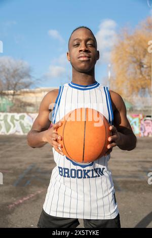 Portrait of basketball player holding ball Stock Photo