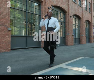 USA, New York City, Smiling businessman talking on smart phone in city Stock Photo