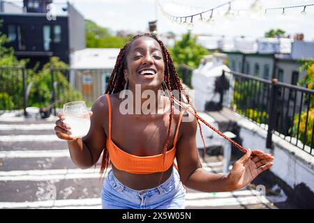 Portrait of smiling woman with drink outdoors Stock Photo