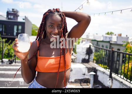 Portrait of smiling woman with drink outdoors Stock Photo