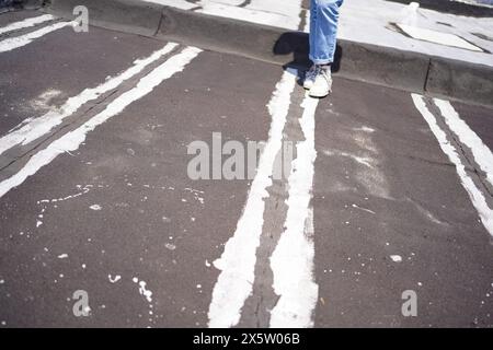 Womans legs on rooftop with painted white lines Stock Photo