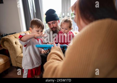 Disabled woman on wheelchair playing with family at home Stock Photo