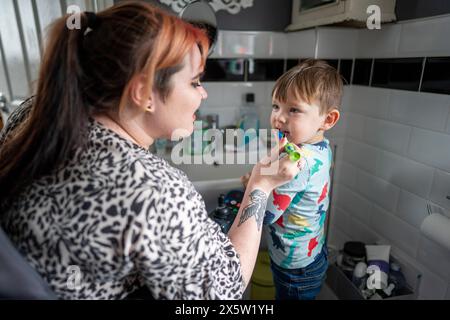 Mother brushing sons teeth Stock Photo