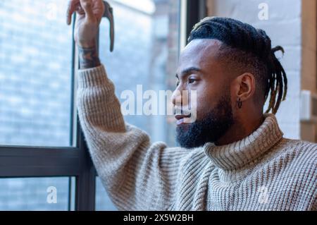 Man looking through window Stock Photo