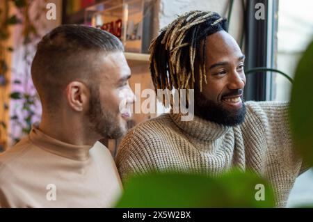 Smiling men looking through window Stock Photo