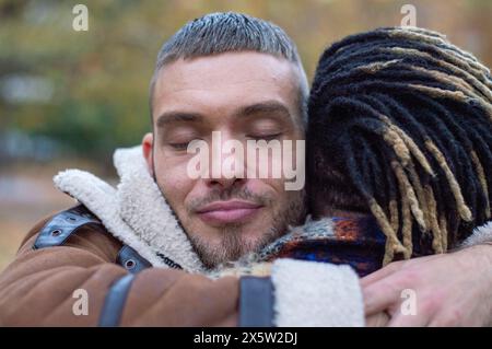 Mid adult men embracing, close up Stock Photo