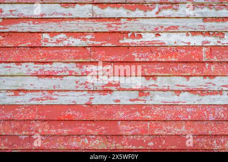 rustic wooden background of a barn or old house wall - planks of weathered pine red painted wood Stock Photo