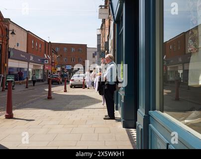 Old man waiting outside a shop Stock Photo