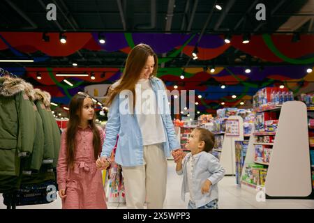 Happy mother with little children in shopping mall Stock Photo