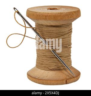 Old wood spool of thread and needle on a white background. Sewing accessories Stock Photo