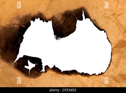 Burnt hole in yellow paper. Burnt paper Stock Photo