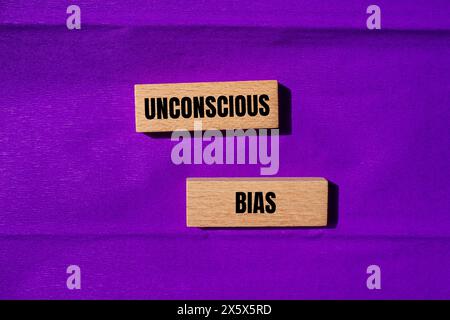 Unconscious bias words written on wooden blocks with purple background. Conceptual unconscious bias symbol. Copy space. Stock Photo