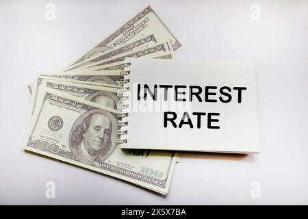 US dollars on white background with text on notepad SHOWING INCREASING INTEREST RATES FINANCIAL CONCEPT Stock Photo