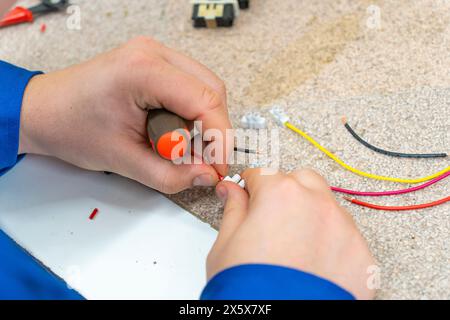 A man doing electronic assembly with colored wires Stock Photo