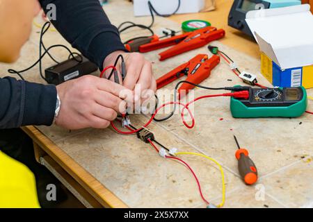 A man doing electronic assembly with a voltage meter Stock Photo