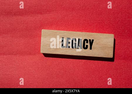 Legacy word written on wooden block with red background. Conceptual legacy symbol. Copy space. Stock Photo