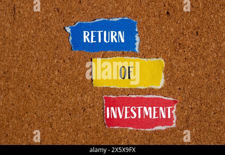 Return of investment words written on ripped paper pieces with brown background. Conceptual business return of investment symbol. Copy space. Stock Photo