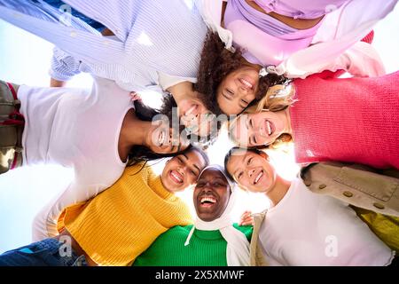 Low angle of a group of multiracial young women looking at camera standing in a circle smiling Stock Photo