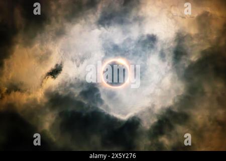 Dramatic total solar eclipse viewed through breaking clouds in Hamilton, Ontario, April 8, 2024. Eerie and atmospheric celestial event. Stock Photo