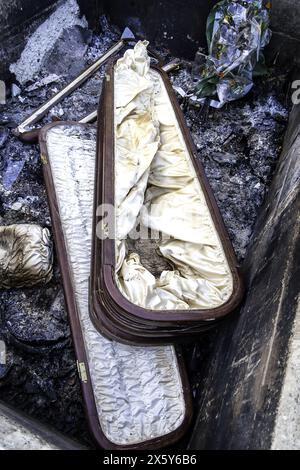 Burnt coffin wit0h flowers in cemetery, religion and burial Stock Photo