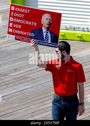 Wildwood, New Jersey, USA. 11th May, 2024. Man holding a sign saying: 'BIDEN: Biggest Idiot Democrats Ever Nominated' as people gather for a ex-President Trump rally on Wildwood Beach, Saturday. (Credit Image: © Brian Cahn/ZUMA Press Wire) EDITORIAL USAGE ONLY! Not for Commercial USAGE! Stock Photo