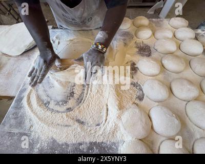 Yzerfontein Western Cape South Africa.  19.04.2024.  An overview of a baker working pastry to form a base for pizza from balls of dough in a bakery. Stock Photo