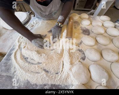 Yzerfontein Western Cape South Africa.  19.04.2024.  An overview of a baker working pastry to form a base for pizza from balls of dough in a bakery. Stock Photo