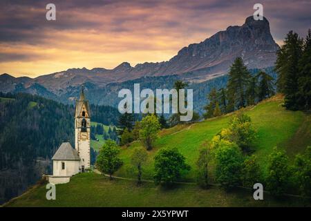 Spectacular traditional Chapel of St Barbara on the slope at beautiful sunset in Dolomites, San Genesio village, Trentino-South Tyrol, Italy, Europe Stock Photo