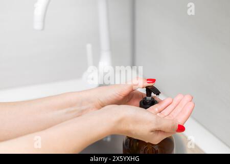 housewife using liquid soap dispenser in the kitchen. bottle of liquid soap. using a soap dispenser. High quality photo Stock Photo