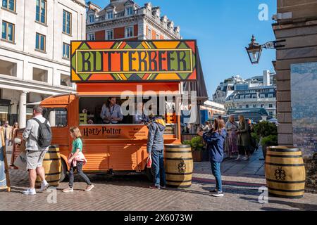 London, UK - 16 April 2022: Orange food and drink truck selling Butterbeer, in Covent Garden, London. This drink was make famous and popular by the Ha Stock Photo