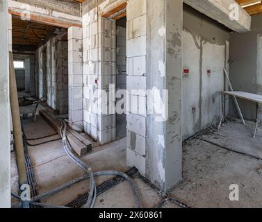 Unfinished basement room under construction, exposed pipes and beams Stock Photo
