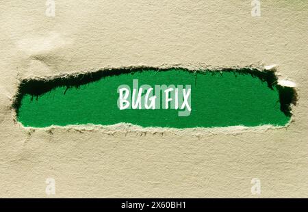 Bug fix words written on ripped cardboard paper with purple background ...