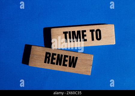 Time to renew written on wooden blocks with blue background. Conceptual time to renew symbol. Copy space. Stock Photo