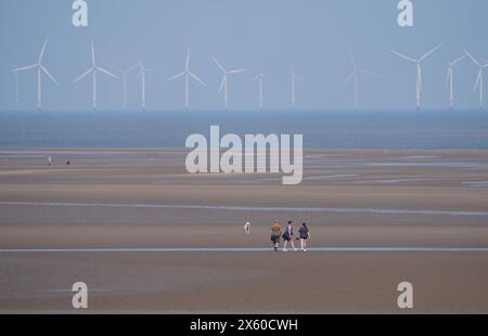 People walking dogs on New Brighton Beach on the Wirral, Merseyside. Picture date: Sunday May 12, 2024. Stock Photo