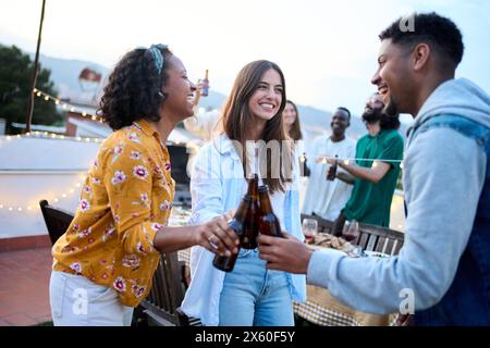 Young multiracial young people dancing together at rooftop party outdoors. Diverse cheerful friends Stock Photo