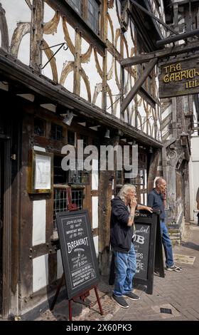 Men smoking cigarettes outside a public house with no smoking allowed inside. England UK Stock Photo