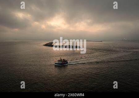 Fishing vessel, sailing past north pier, IJmuiden, Netherlands Stock Photo