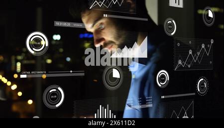 Image of infographic interface over caucasian businessman working in office at night Stock Photo