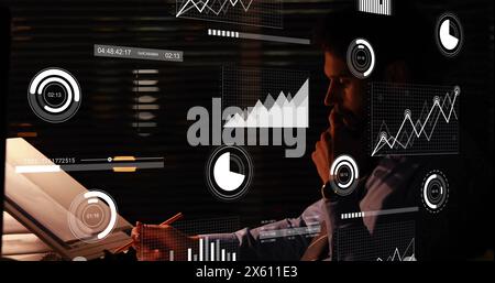 Image of infographic interface over focused caucasian businessman drawing blueprint in office Stock Photo