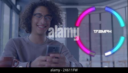 Image of neon speedometer against biracial man smiling while using smartphone at a cafe Stock Photo