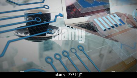 Image of graphs and circuit board pattern over coffee cup and caucasian woman working on laptop Stock Photo