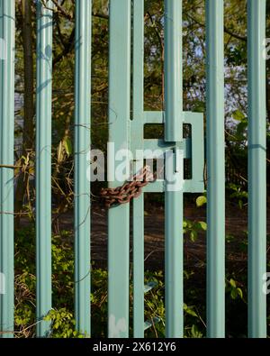 Locked gates of former steel industry factory, now overgrown wasteland, West Midlands Stock Photo