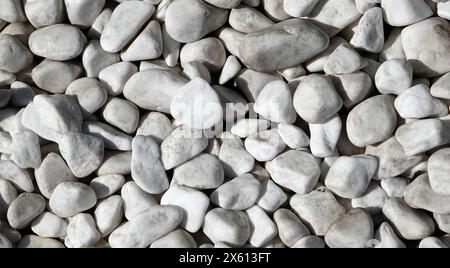 Background - white tumbled marble stones on the coast of a unique sea ...