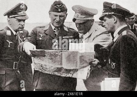 Goering with, left, General Jeschonnek, and right, General Loerzer, studying a map while planning an attack on Britain, 1940. Hermann Wilhelm Göring or Goering, 1893-1946.  German politician, military leader, and convicted war criminal.  Hans Jeschonnek, 1899 – 1943. German military aviator in the Luftstreitkräfte during World War I.  Bruno Loerzer, 1891 – 1960.  German air force officer during World War I and World War II.  From The War in Pictures, Sixth Year. Stock Photo