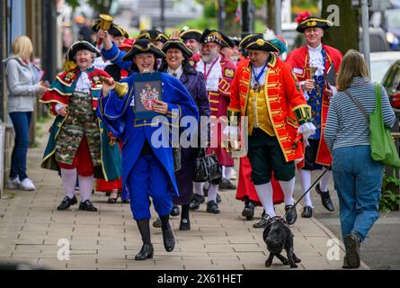 Town criers (bellmen & bellwomen in colourful braided crier's livery uniforms) walking & parading - Brook Street, Ilkley, West Yorkshire England UK. Stock Photo