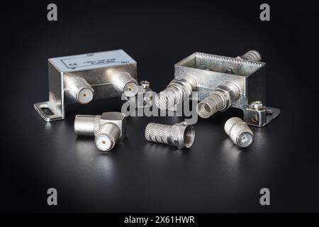Antenna splitters and various F-type connectors on a black background, close-up Stock Photo