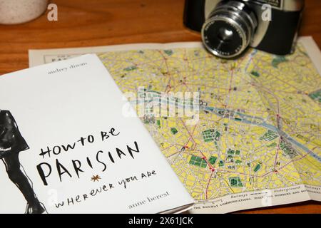 Book How to be a Parisian, wherever you are. By Sophie Mas, Audrey Diwan, Caroline de Maigret, Anne Berest. Themed on Paris map with vintage camera Stock Photo